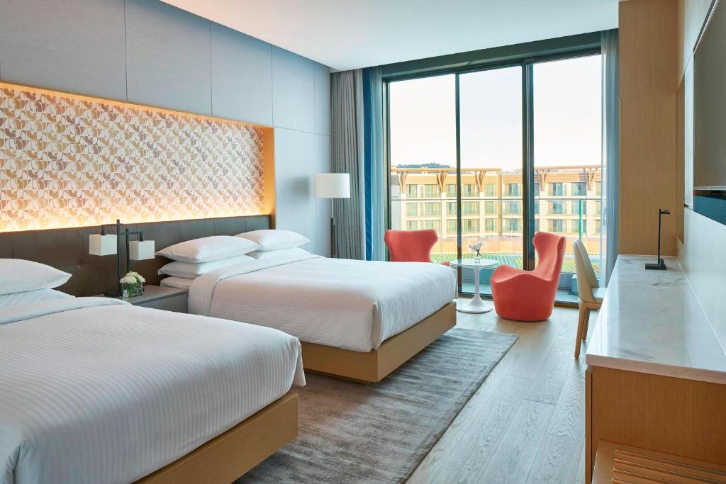 Postel nebo postele na pokoji v ubytování Marriott Jeju Shinhwa World Hotel