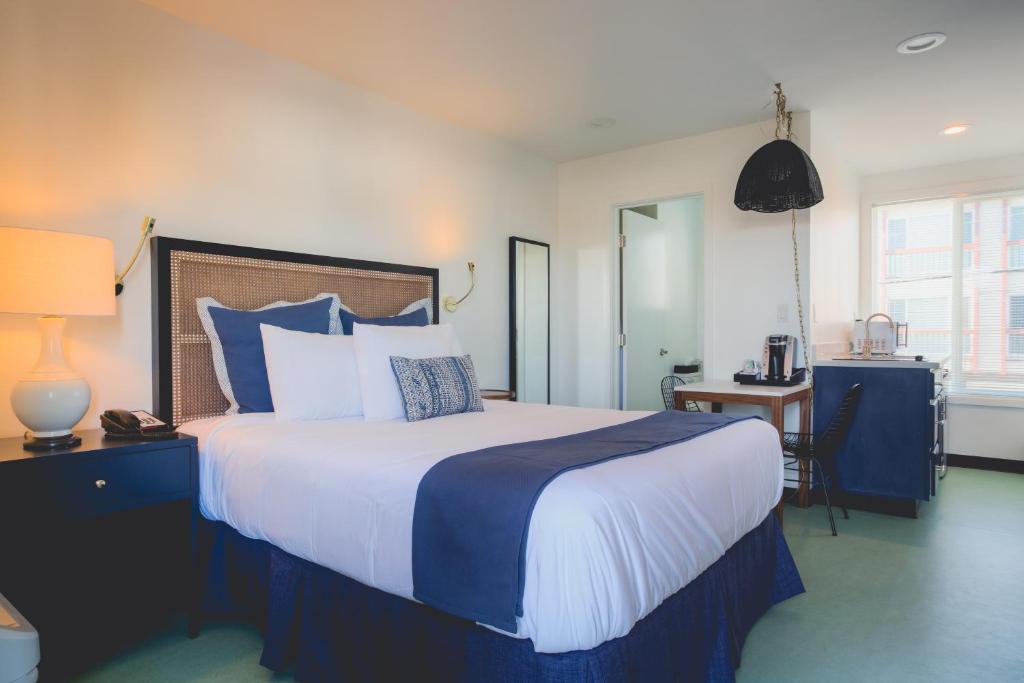 a bedroom with a large bed with blue and white pillows at Mylo Hotel in Daly City