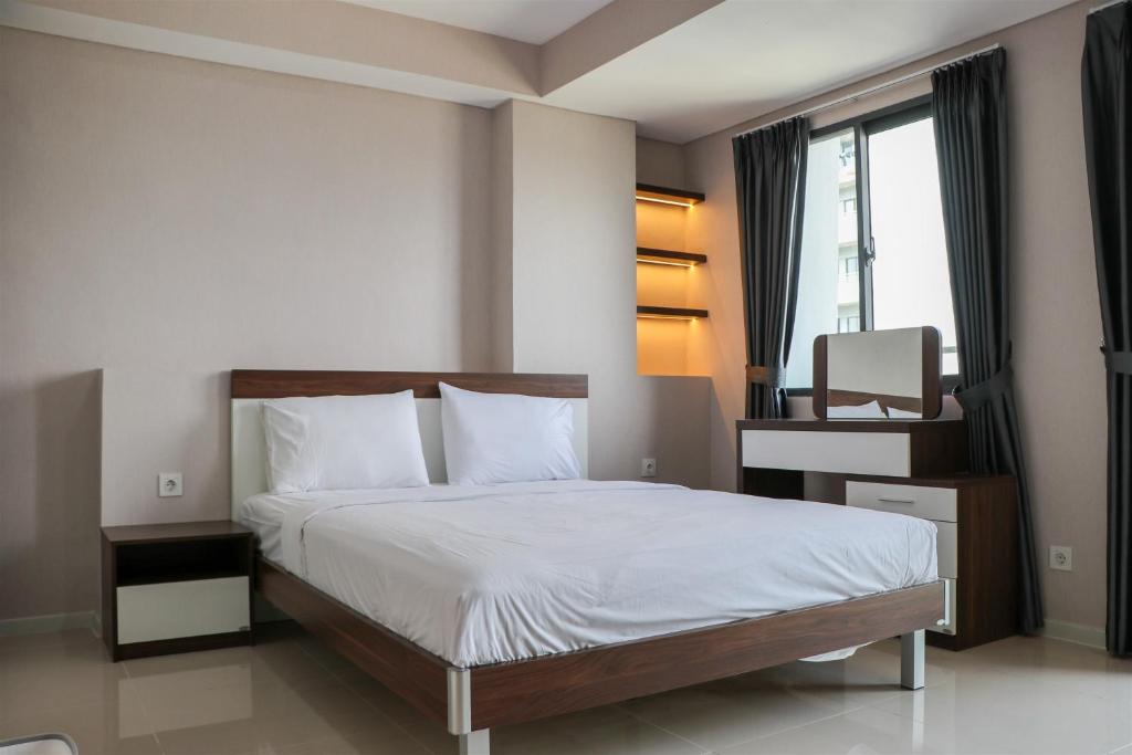 Un pat sau paturi într-o cameră la Cozy Stay Studio at 27th Floor Daan Mogot City Apartment By Travelio