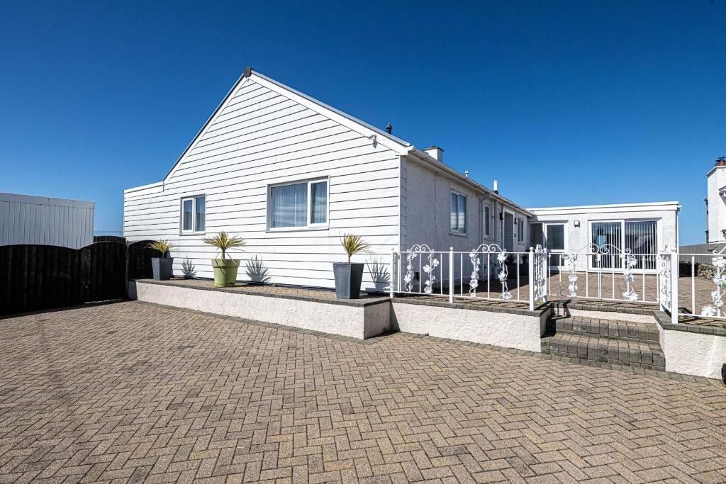 a white house with a fence in front of it at Swn y Don in Cemaes Bay