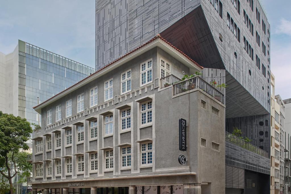 シンガポールにある21 Carpenter, Singapore, a Member of Design Hotelsの高層ビルの前にバルコニー付きの建物
