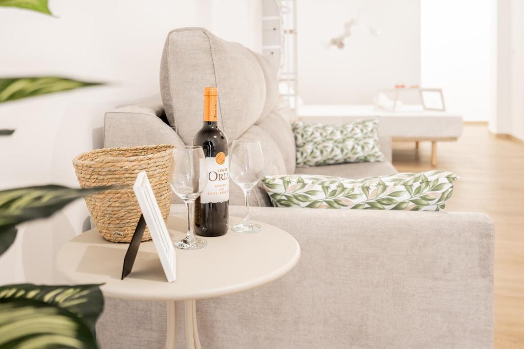 a bottle of wine on a table next to a couch at VisitVal Flats 3 in Valencia