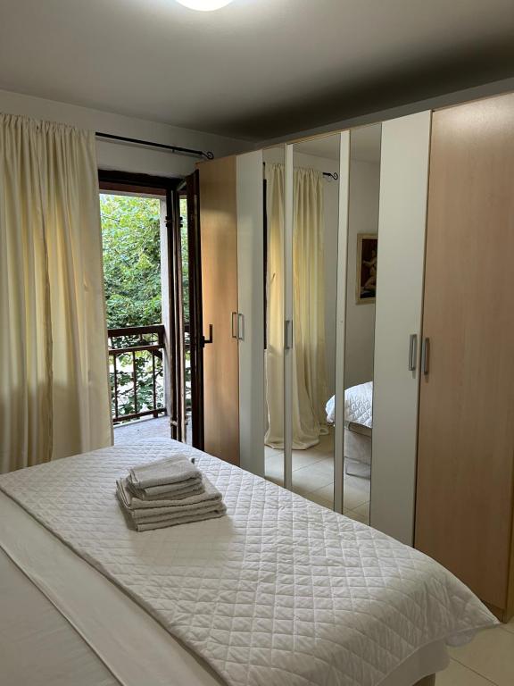 a bedroom with a white bed with a mirror at House Pravilovic apartments in Cetinje