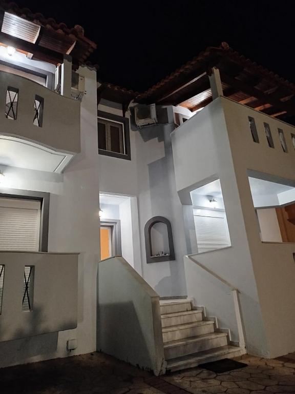 a white house with stairs in the middle at Panagio House in Pefki