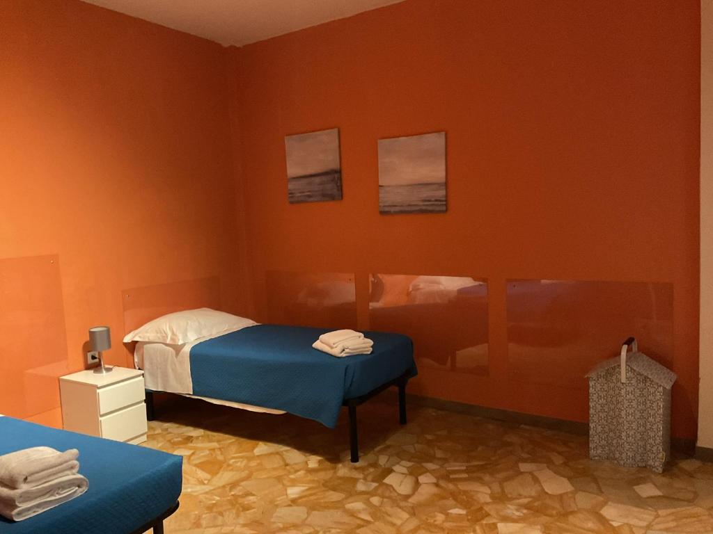 um quarto com paredes cor de laranja, uma cama e uma mesa em Oro B22 em Florença