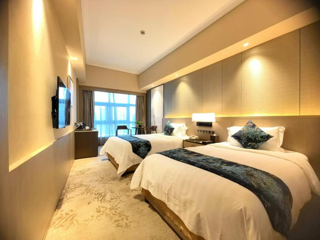Postel nebo postele na pokoji v ubytování Jin Jiang Pine City Hotel
