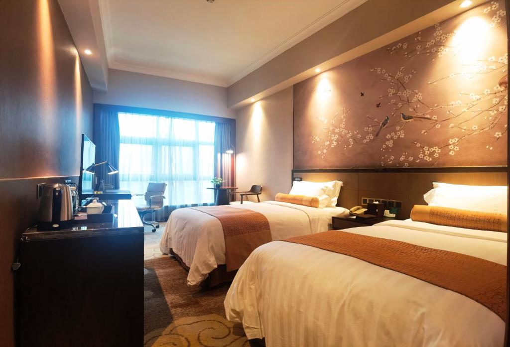 Postel nebo postele na pokoji v ubytování Jin Jiang Pine City Hotel