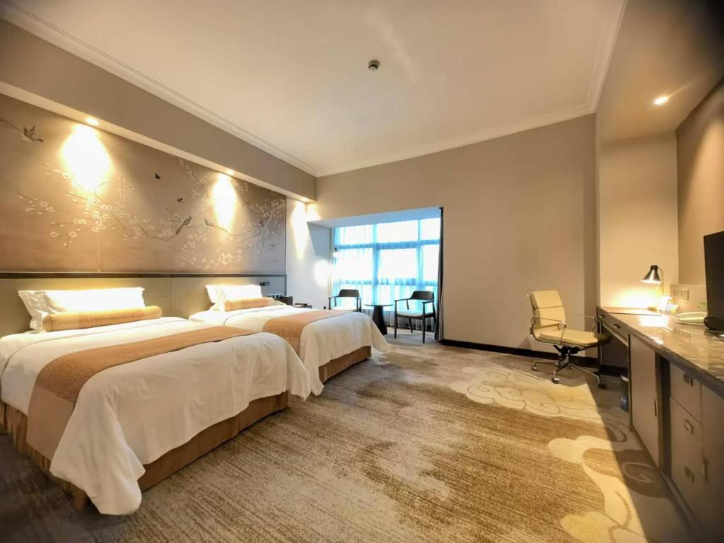 Postel nebo postele na pokoji v ubytování Jin Jiang Pine City Hotel