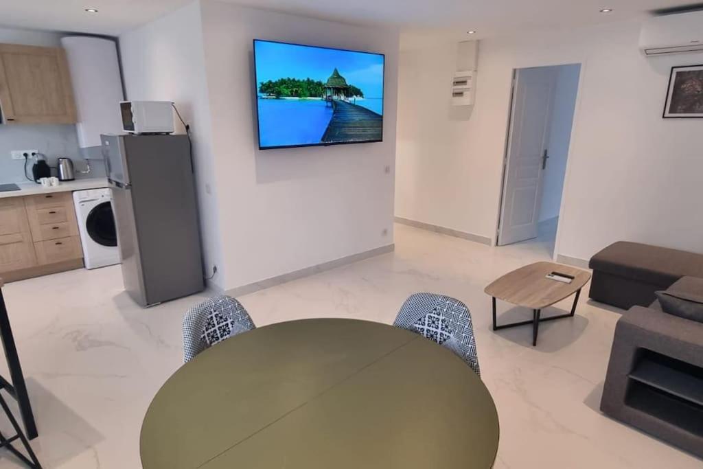 un salon avec une table et une télévision au mur dans l'établissement Appartement Lacassagne-près de la Gare, à Lyon
