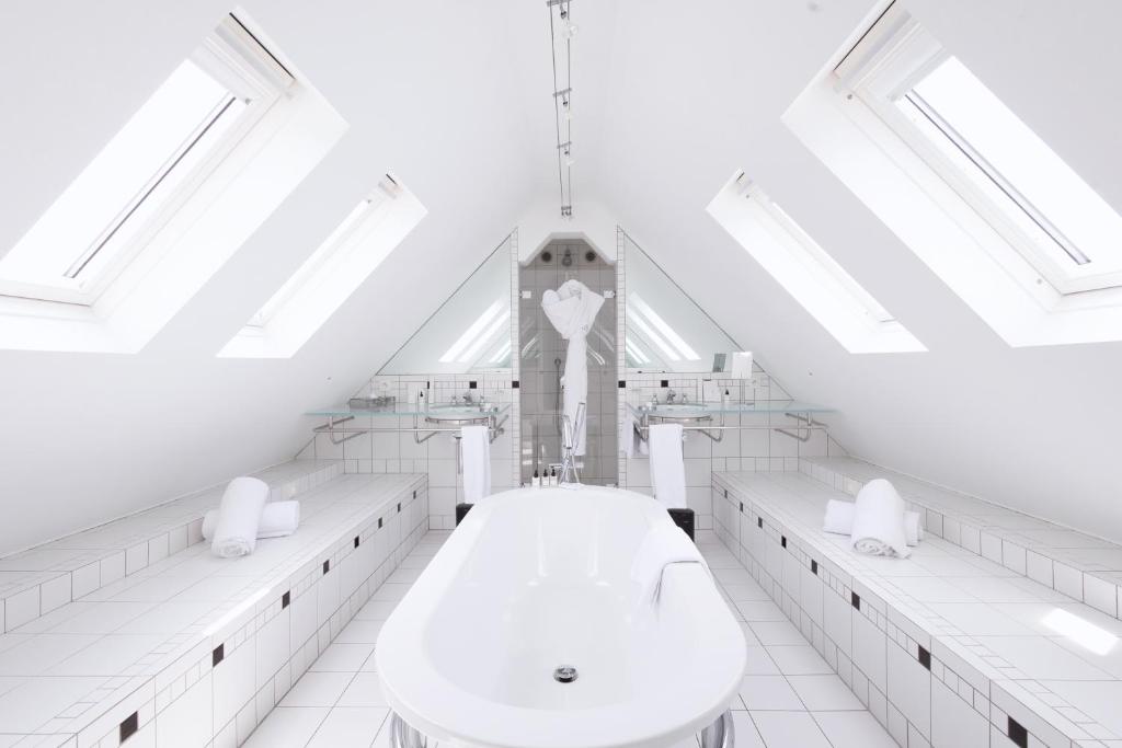 a white bathroom with a clock tower in the background at L'Agapa Hôtel - Spa Codage in Perros-Guirec