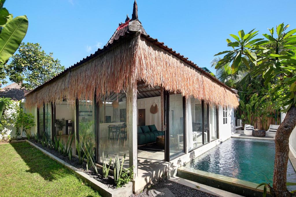 a villa with a swimming pool and a resort at Villa Maison Pastis Canggu in Canggu