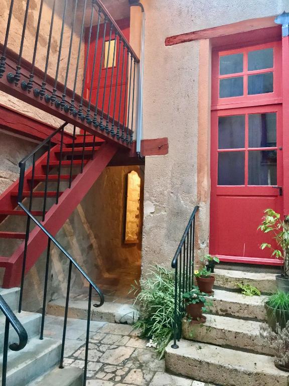 - une porte rouge sur une maison avec des escaliers dans l'établissement Sur la Route de Beauval, à Saint-Aignan