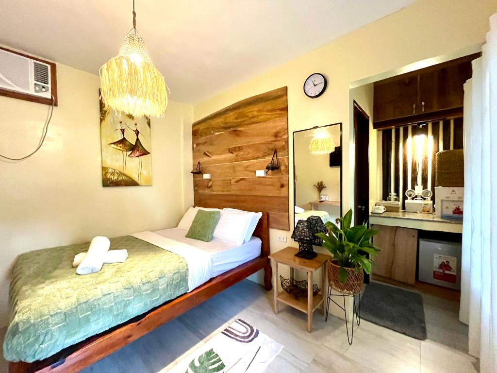 una camera da letto con un letto e un orologio sul muro di Cozy Bungalow Isa with AC and Generator in General Luna a General Luna