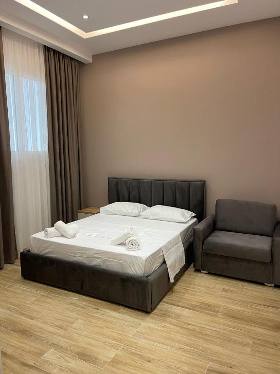 a bed and a chair in a room at Florida Rooms in Vlorë