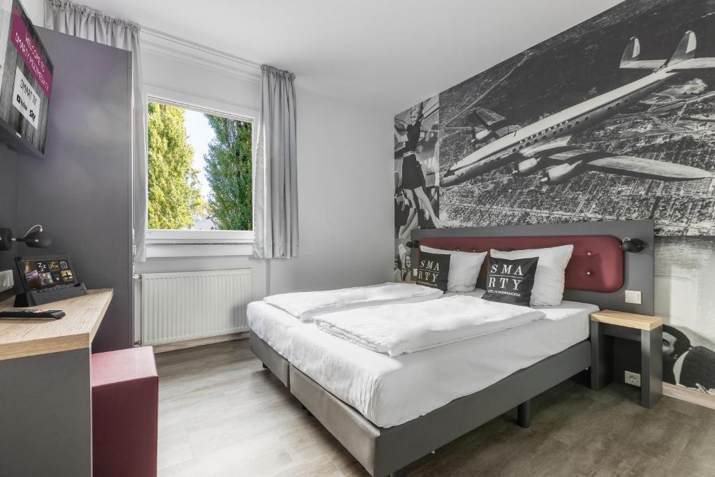 Postel nebo postele na pokoji v ubytování SMARTY Airport Cologne Hotel - KONTAKTLOSER SELF CHECK-IN