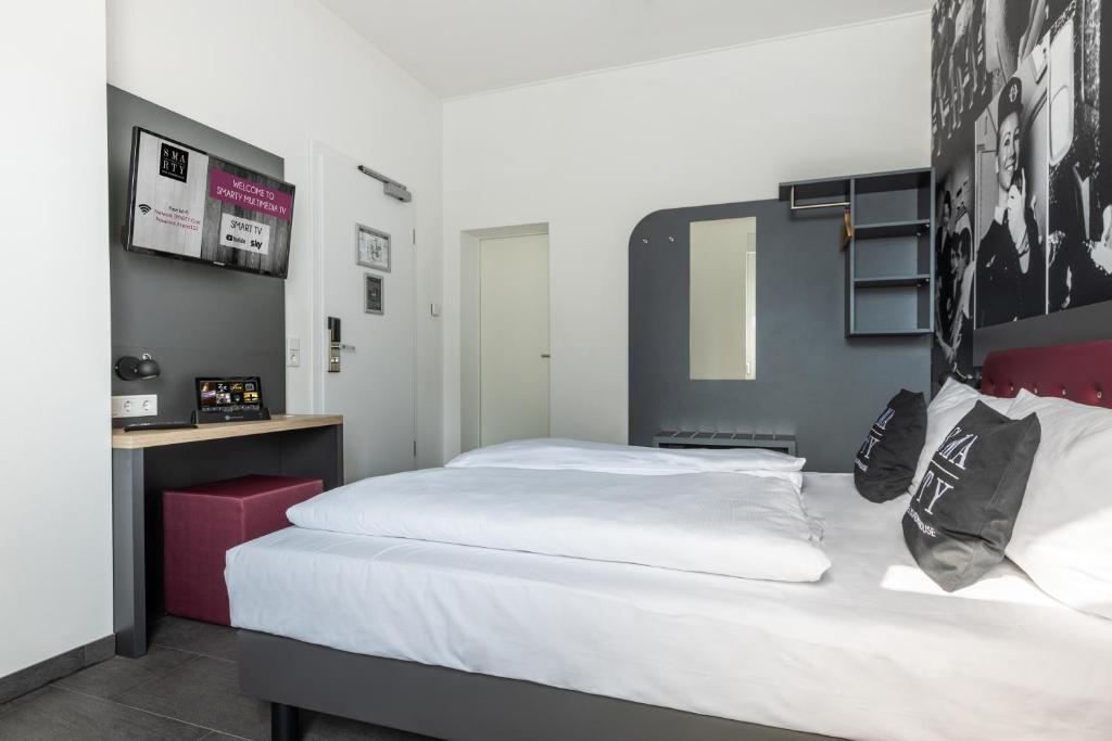 Postel nebo postele na pokoji v ubytování SMARTY Airport Cologne Hotel - KONTAKTLOSER SELF CHECK-IN