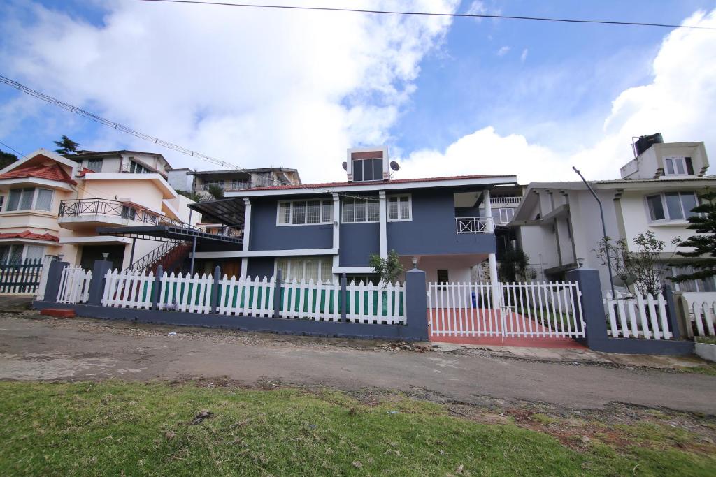 una staccionata bianca davanti a una casa di Tiger Hill Homestay a Ooty