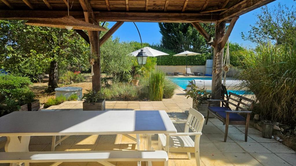 un patio avec une table et des chaises et une piscine dans l'établissement La Serva, à Les Lèches
