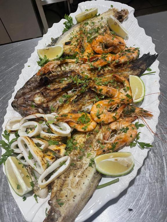 a plate of seafood with shrimp and lemon slices at Villa La Falaise in Oualidia