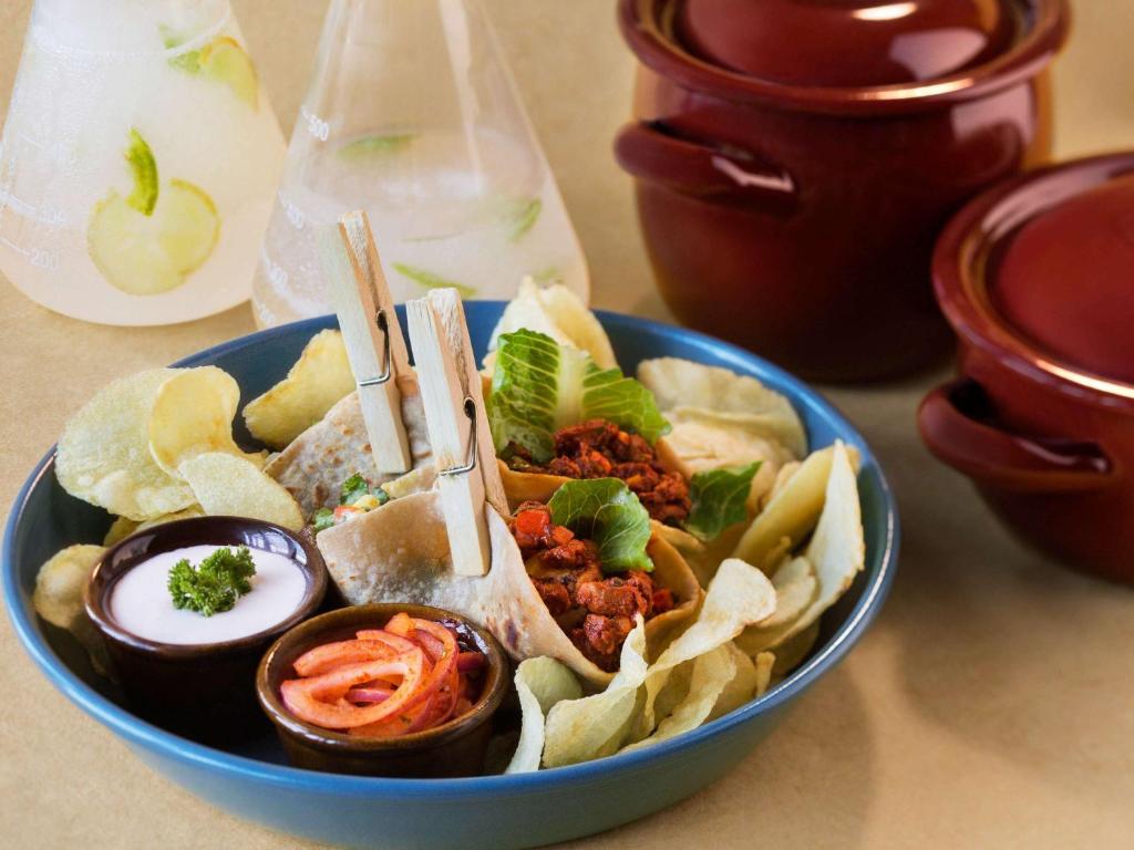 a blue bowl of food with chips and meat at ibis Pune Viman Nagar - An Accor Brand in Pune