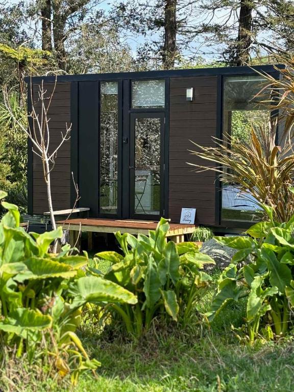 a modern cabin in the woods with plants at Golden Valley Retreat by Tiny Away in Waihi