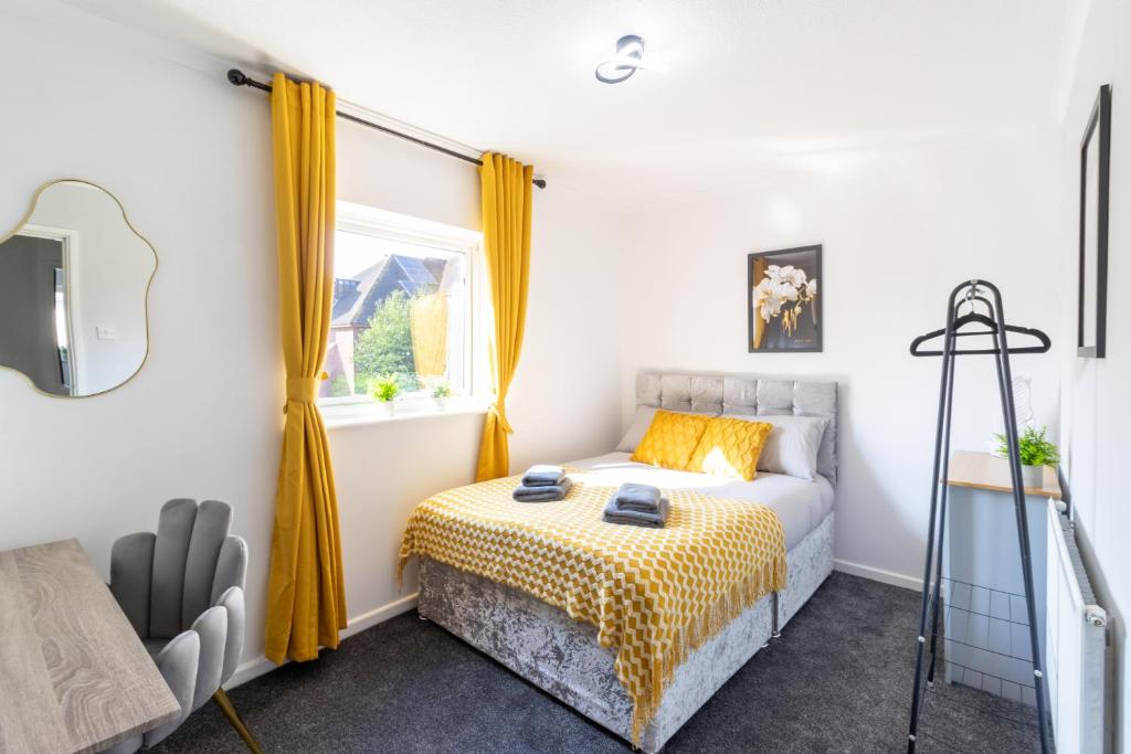 a bedroom with a bed with yellow curtains and a window at Open Mind Property - 4 Beds 2 Bathrooms & Parking in Portsmouth