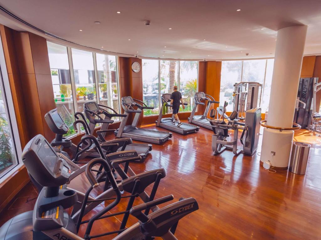 a gym with a bunch of treadmills at Mövenpick Hotel Bahrain in Manama