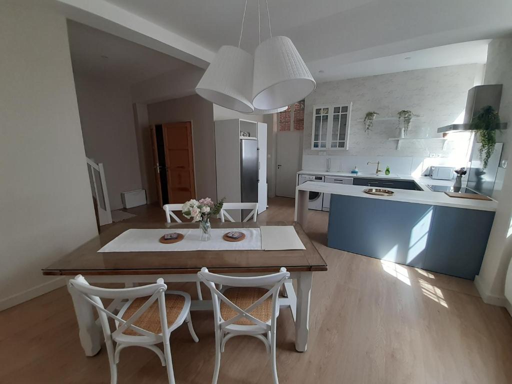 une cuisine avec une table et des chaises dans une cuisine dans l'établissement Spacieux et Cosy Duplex centre historique - 2 Chambres - Transport facile, à Valenciennes