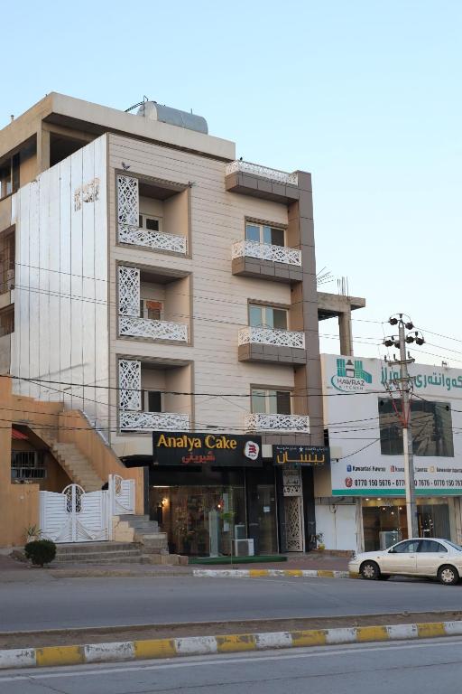 a building with a car parked in front of it at Besan Motel in As Sulaymānīyah