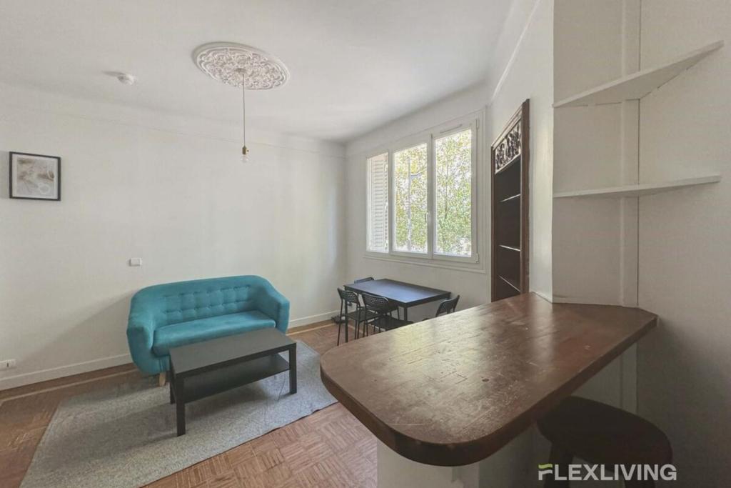un salon avec une chaise bleue et une table dans l'établissement Flexliving - whole flat - Verdun, à Paris