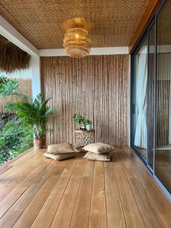 a room with a wooden floor and a chandelier at Why Nam Beach in Haad Yuan