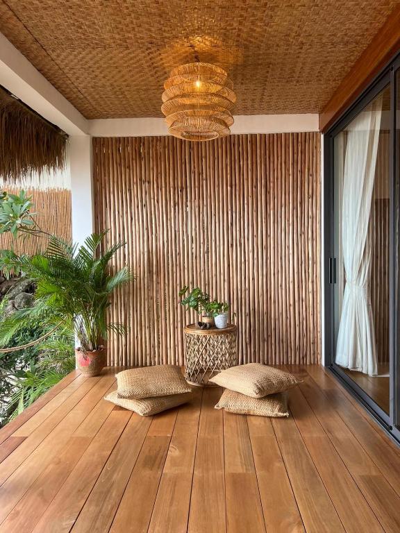 a room with a wooden floor and a chandelier at Why Nam Beach in Haad Yuan