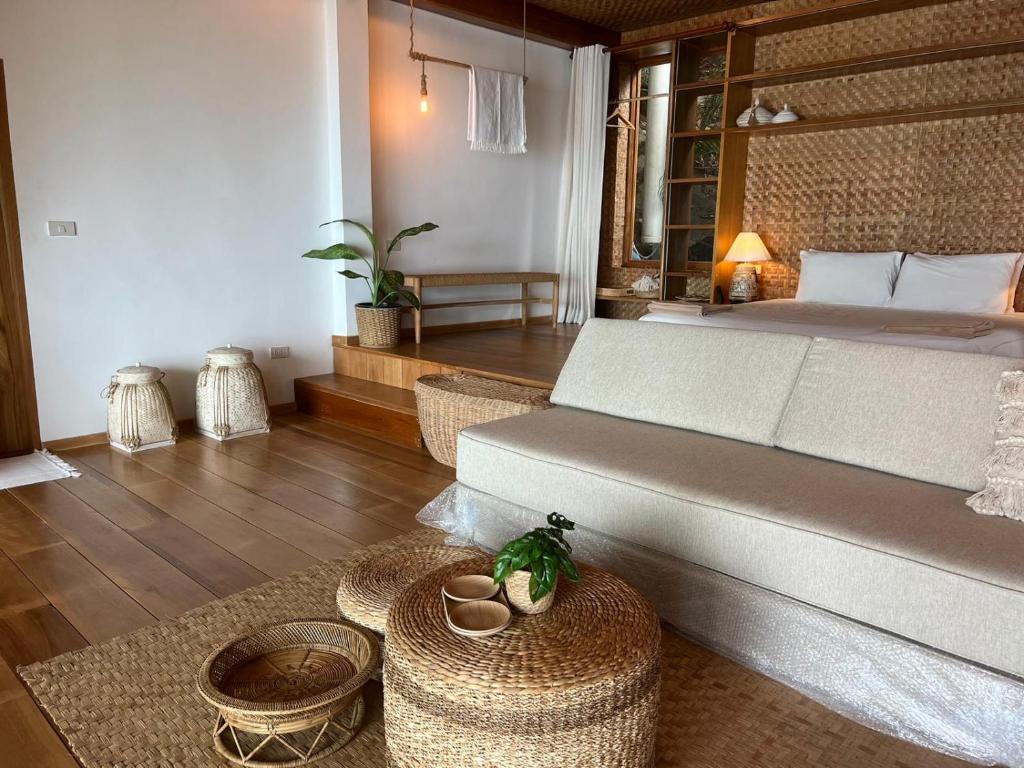 a room with a bed and a couch and a table at Why Nam Beach in Haad Yuan