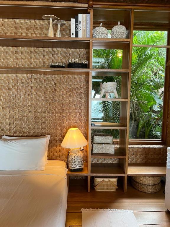 a bedroom with a bed and a book shelf at Why Nam Beach in Haad Yuan