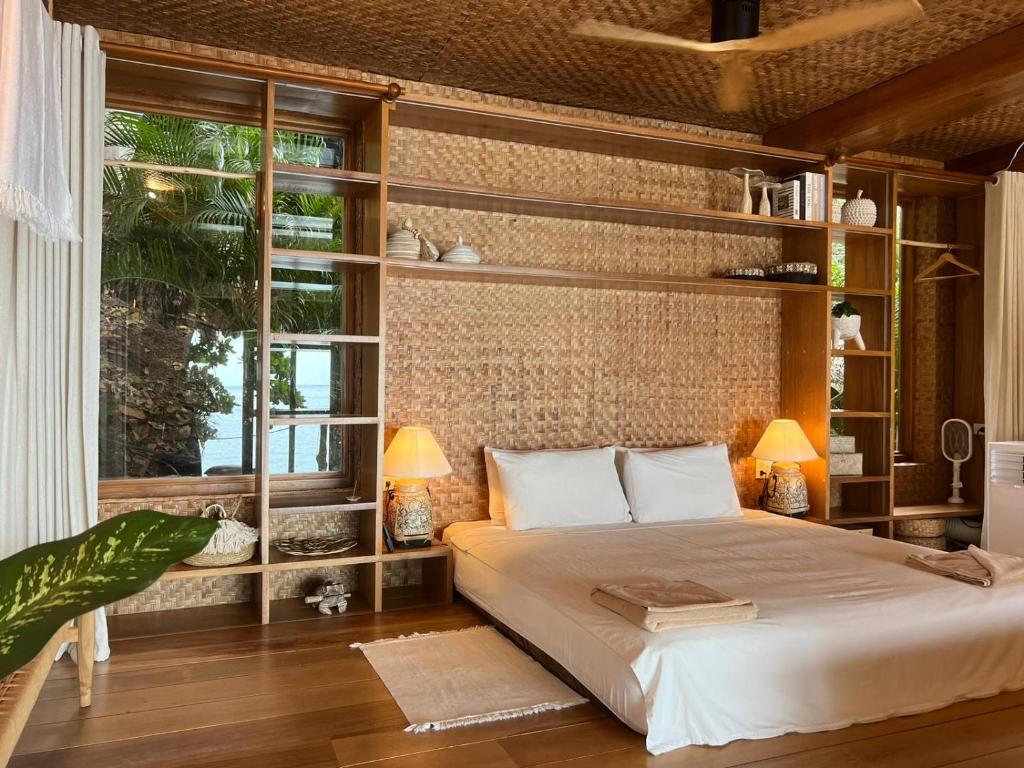 a bedroom with a bed and a large window at Why Nam Beach in Haad Yuan