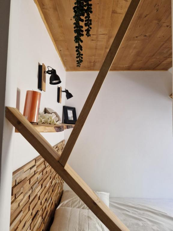 un lit dans une chambre avec un plafond en bois dans l'établissement la Kabane du Verdon, à Allos
