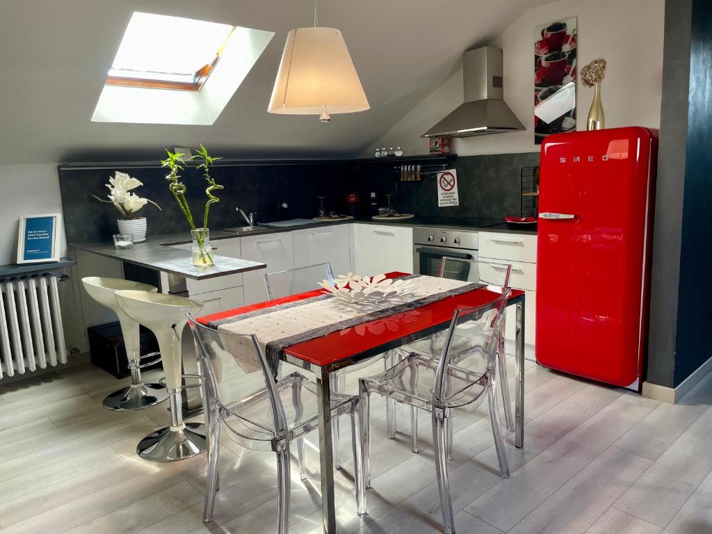 una cucina con frigorifero rosso e tavolo con sedie di Casa Ottavio Torino a Torino