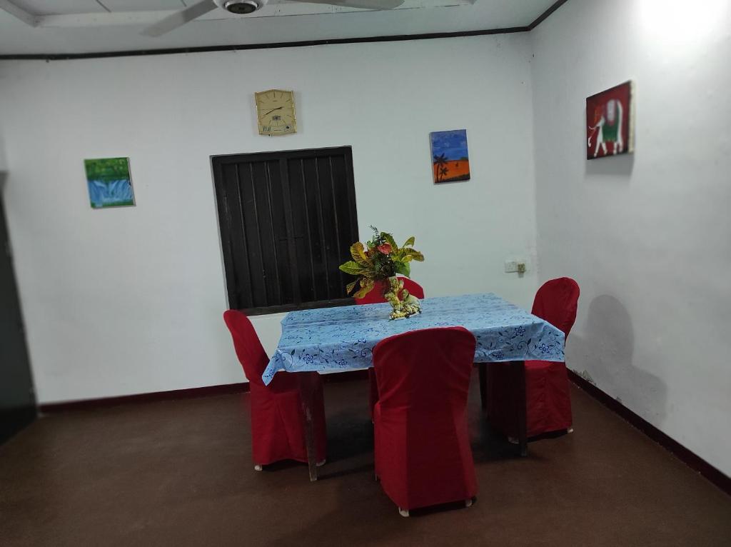 a table in a room with red chairs and a blue table cloth at Asal Villa in Walliwala East