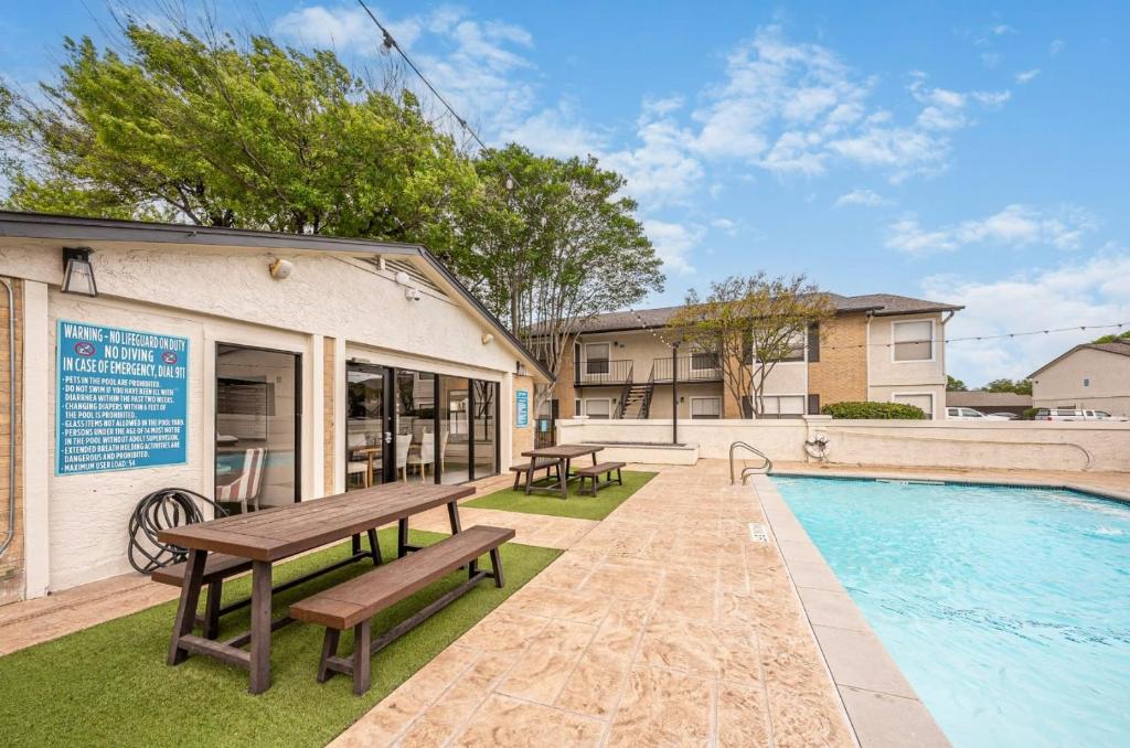 una piscina con tavolo da picnic e panchine accanto a un edificio di Pet-Friendly 1BR Apt - Pool Near All Attractions a New Braunfels
