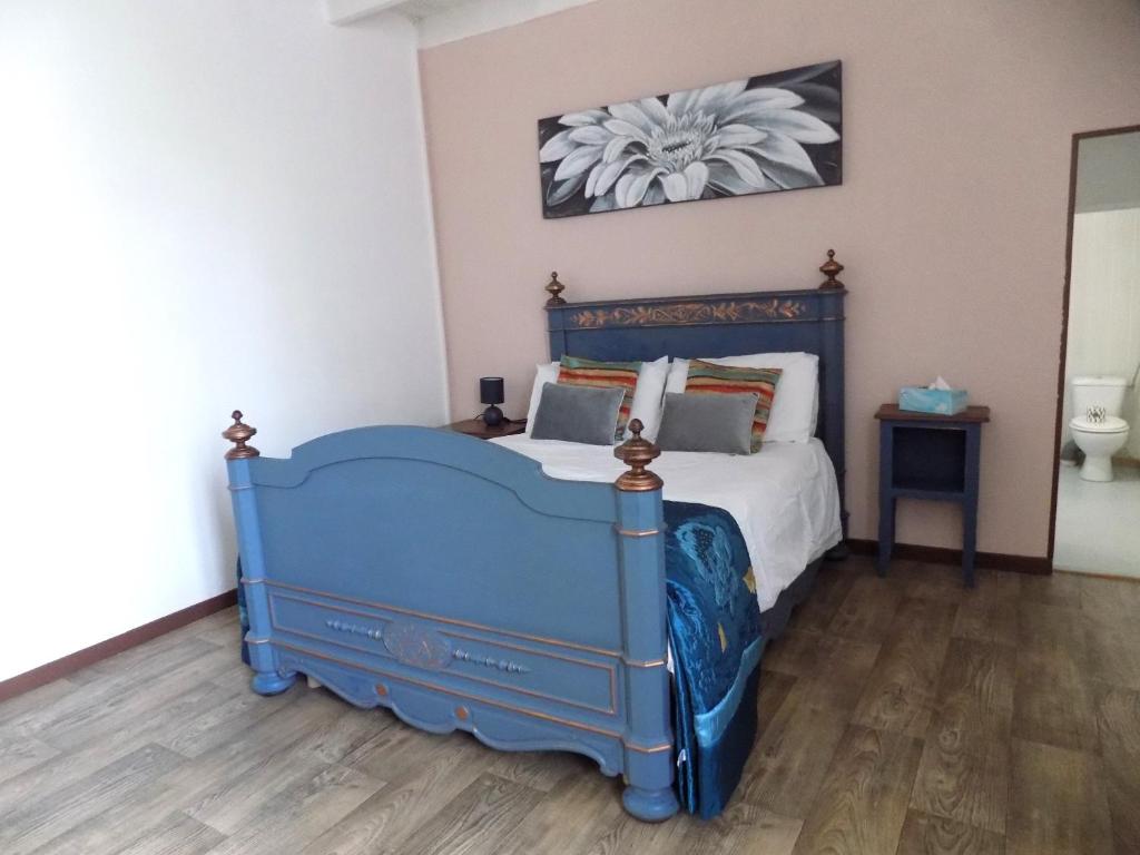 a bedroom with a blue bed in a room at La maisonnette in Les Adjots