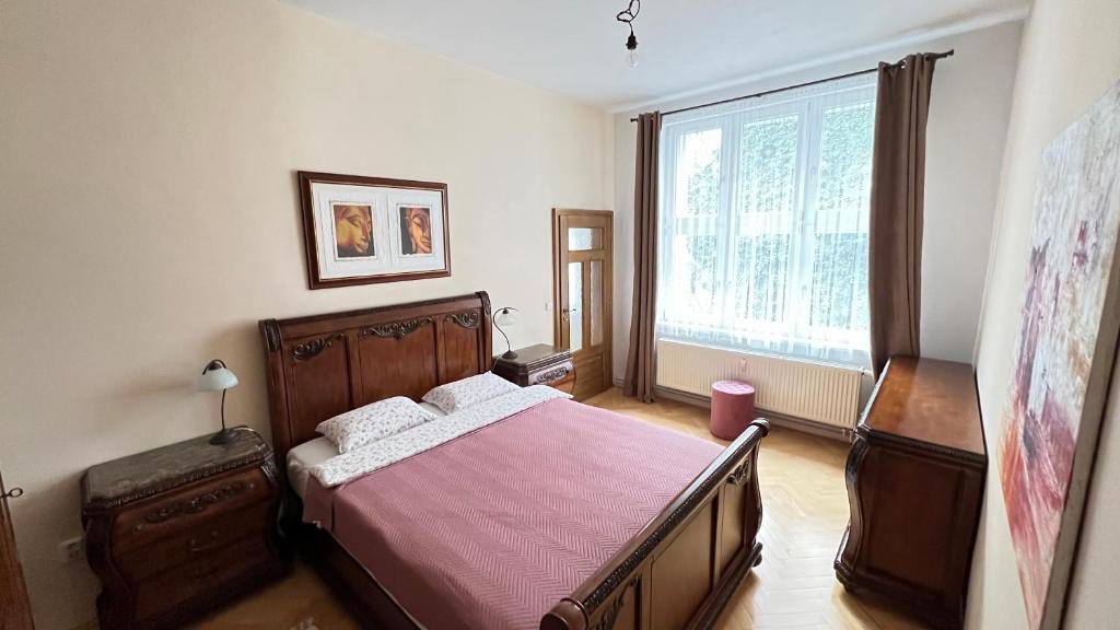 a bedroom with a bed and a large window at Cozy apartment in the city centre in Olomouc