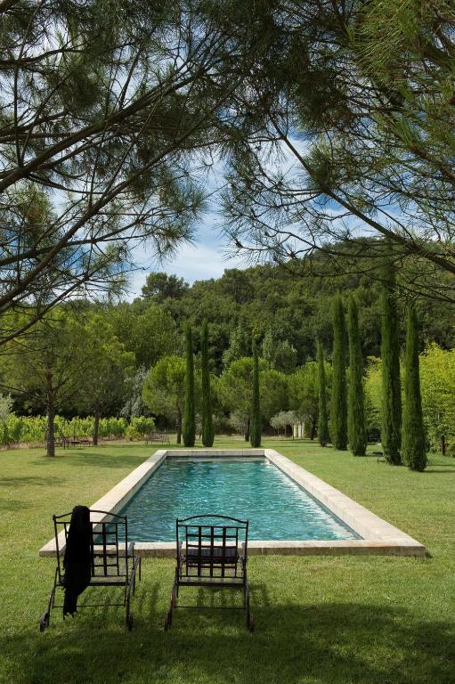 - une piscine dans une cour avec deux bancs dans l'établissement La Cour Intérieure Ménerbes, à Ménerbes