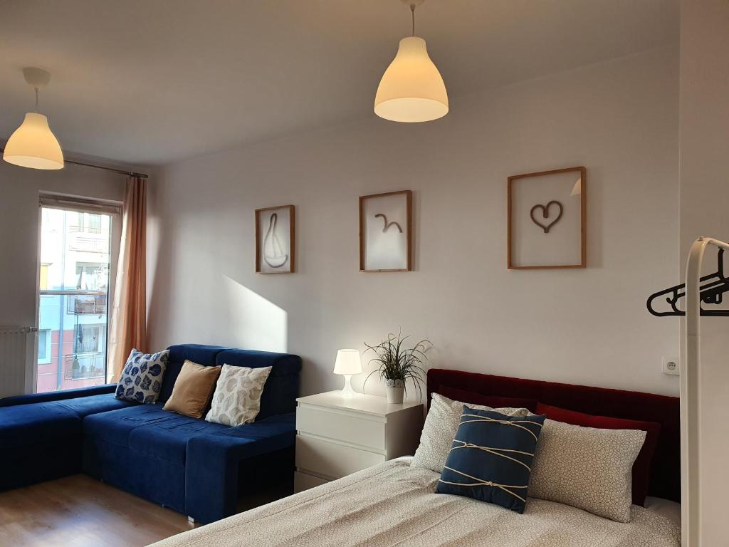 ブワディスワボボにあるApartament Mewka XVIIIのベッドルーム(青いソファ、ベッド付)