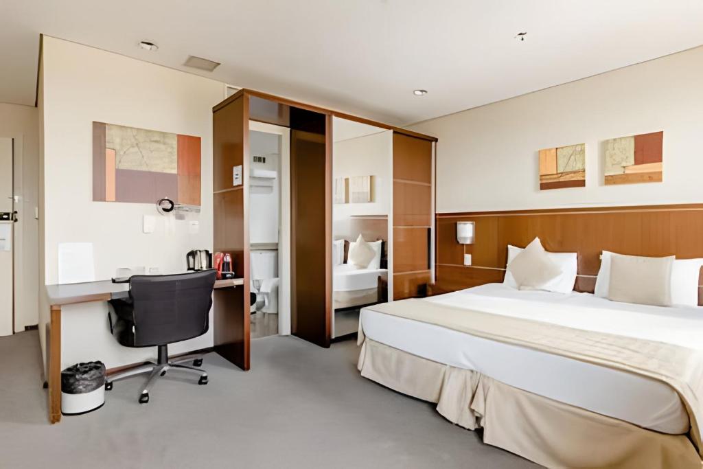 a hotel room with a bed and a desk at Flats Osasco Trade Center in Osasco