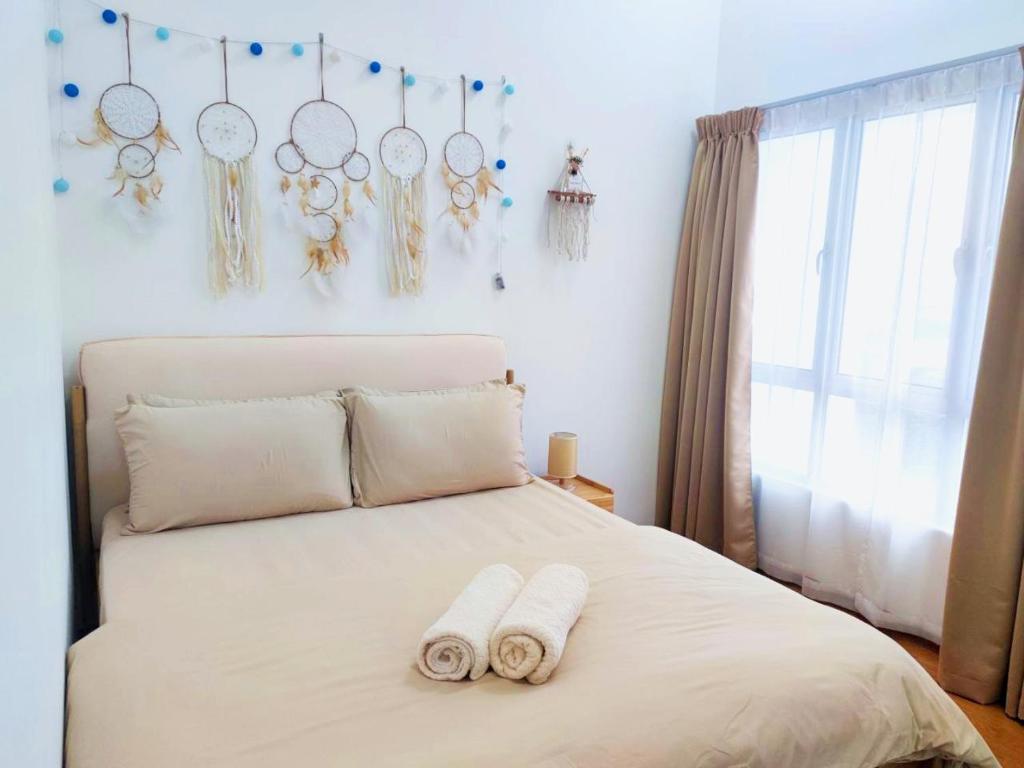 a bedroom with a bed with two towels on it at CupidWood Residensi Ostia Bangi with Pool free NEFLIX, Wifi, Parking in Bandar Baru Bangi