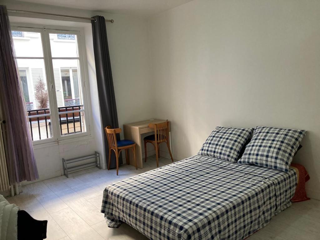 une chambre avec un lit, une table et une fenêtre dans l'établissement studio, à Paris