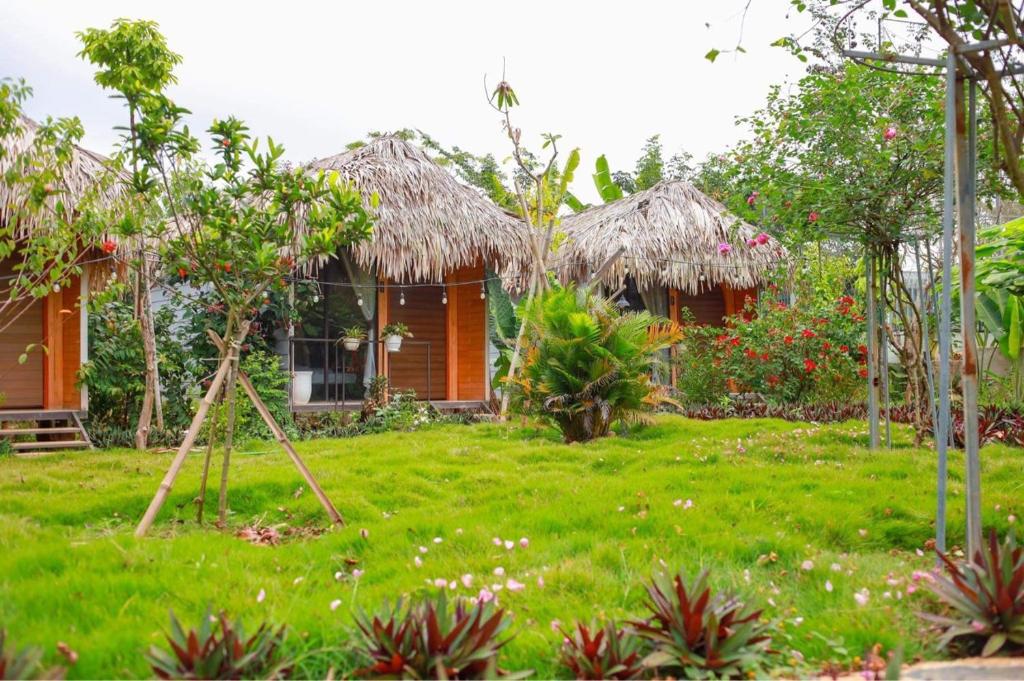 a house with a yard with a grass yard at Bó Bun Homestay Mộc Châu in Mộc Châu