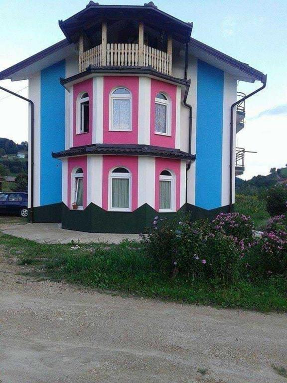 un edificio rosa e blu con un balcone di Vila Anđelija a Velika Kladuša