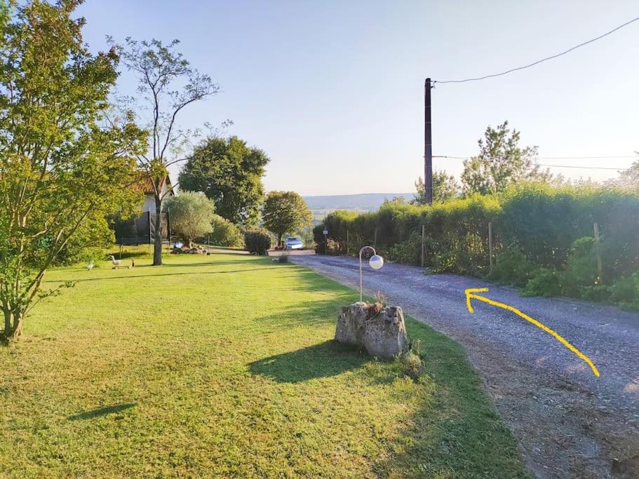 Saint-Jean-de-ThuracにあるDomaine de la Crête Gîte Les CoCottes ZENの道路脇に腰掛けた切り株