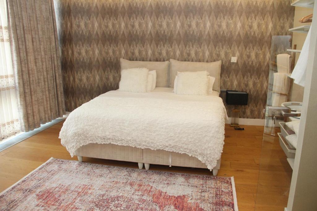 a bedroom with a bed with white sheets and a rug at Lovely One Bedroom Appartment-530 in Istanbul
